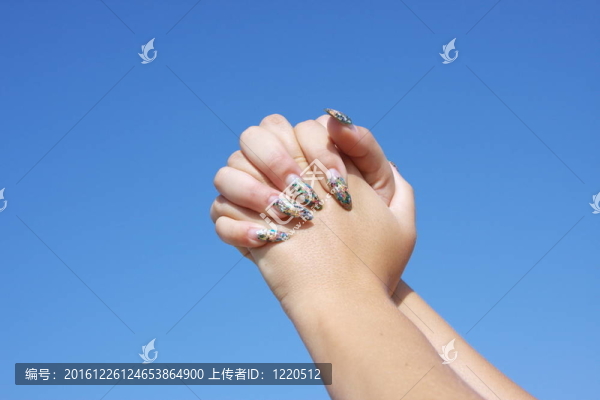 女人的手放在一個(gè)背景蔚藍(lán)的天空