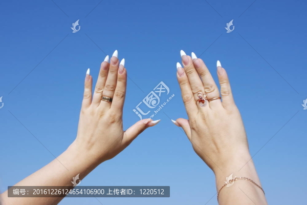女人的手放在一個(gè)背景蔚藍(lán)的天空