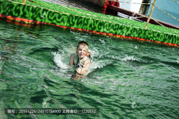 瞇著眼睛的男孩和海豚游泳