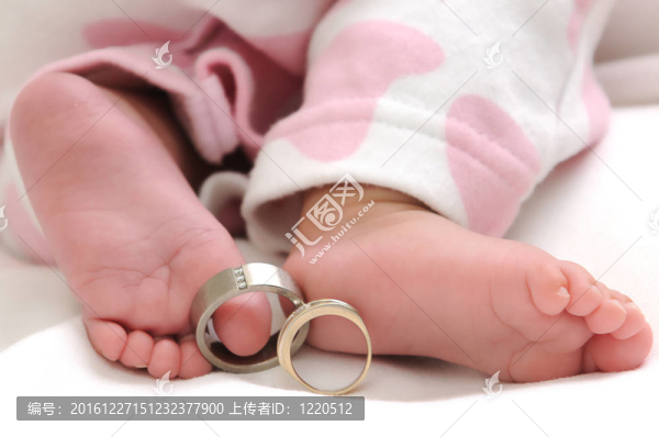一個穿著白色和粉色衣服的女嬰的結(jié)婚戒指