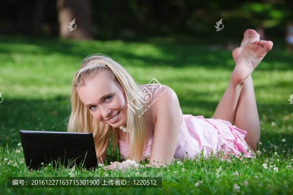 在公園里使用筆記本電腦的年輕女人