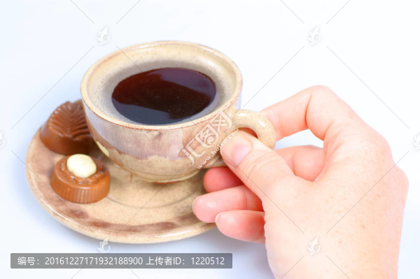 果仁巧克力；杯；黑咖啡和女性手上白色