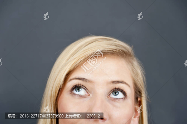 年輕女子抬頭仰望藍(lán)色背景