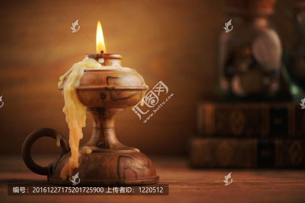 木制桌上的舊蠟燭；背景中的舊書(shū)