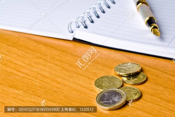 筆記本上的硬幣和墨水筆