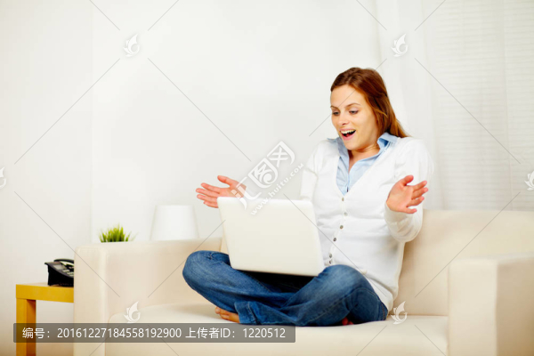 漂亮的女孩在沙發(fā)上工作與筆記本電腦