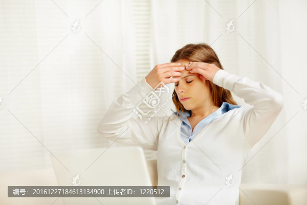 美麗的女人頭痛從筆記本電腦