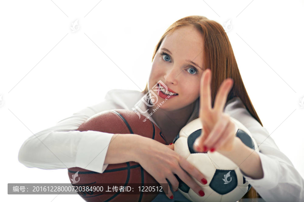 迷人的女孩拿著足球和籃球球