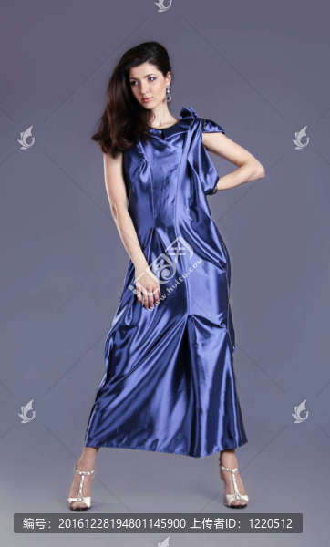 在藍(lán)色的衣服擺在灰色背景的年輕的黑發(fā)女士