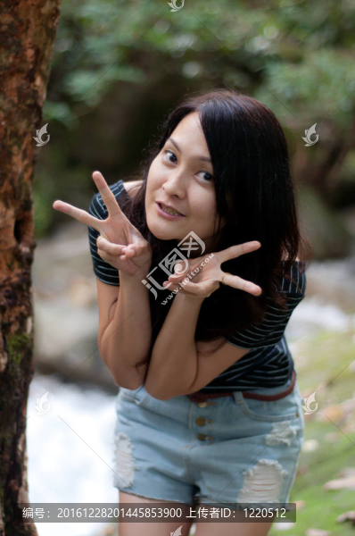 亞洲泰國美女站在瀑布的樹上