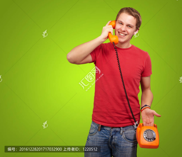 年輕人在綠色背景下用老式電話交談的肖像