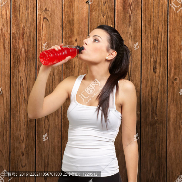 對(duì)一個(gè)年輕女人的肖像運(yùn)動(dòng)飲用等滲飲料