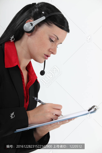 戴耳機(jī)和記事本的年輕女人