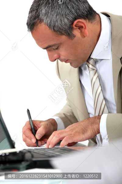 男人坐在書桌前寫字