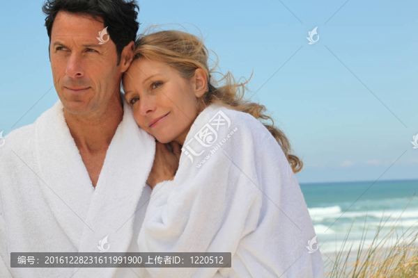 夫婦站在海灘上穿著浴袍