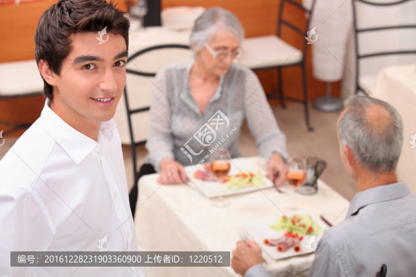 成熟夫婦和年輕服務(wù)員在餐廳