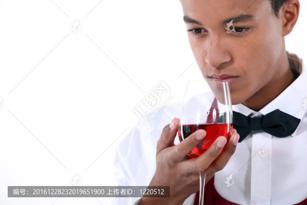 年輕的侍者聞著一杯玫瑰酒