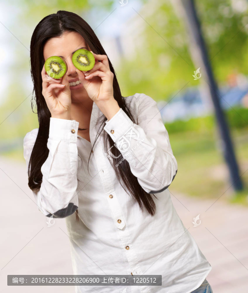 美麗的女人在她的眼前舉行獼猴桃切片肖像