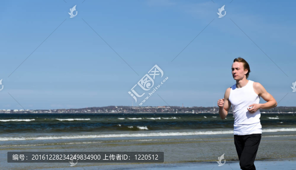 在海灘上跑步的年輕男子