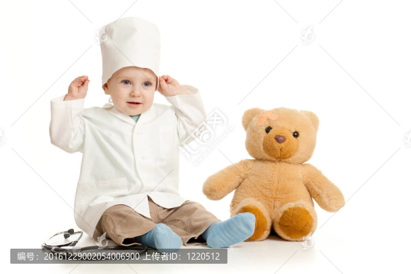 可愛的男孩與醫(yī)生的衣服和泰迪熊超過白色