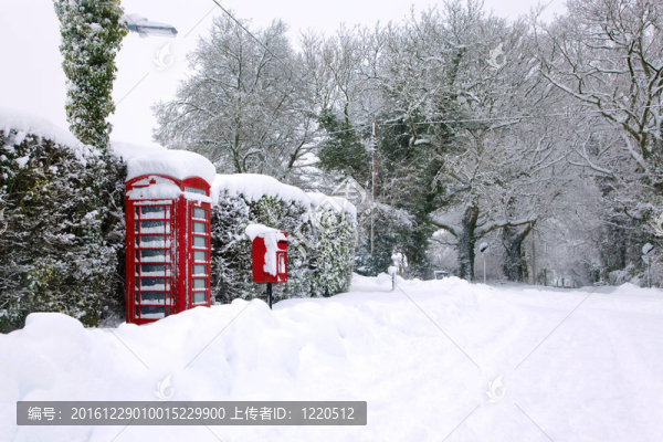 雪中的紅色電話亭后面