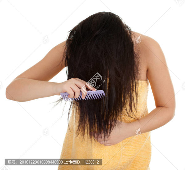 用黃毛巾梳理長發(fā)婦女