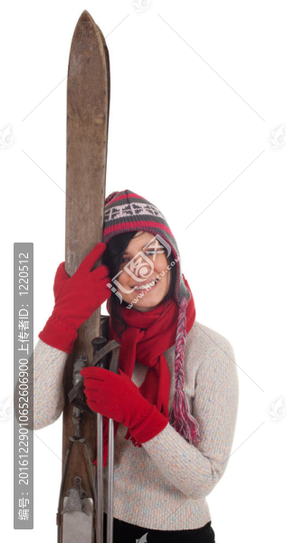 微笑的年輕女子在冬季帽持有舊木滑雪