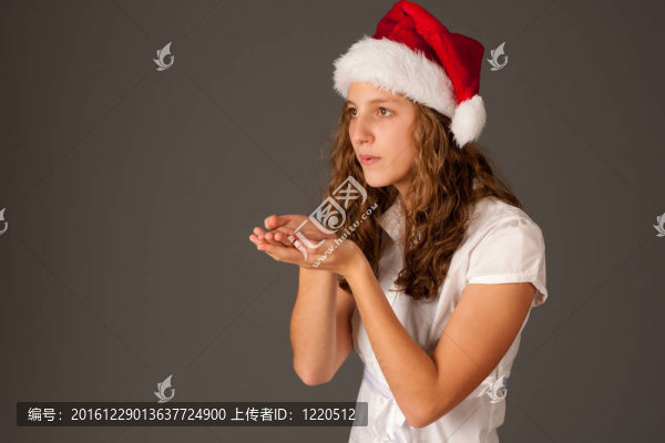 迷人的女孩在圣誕帽孤立的灰色背景