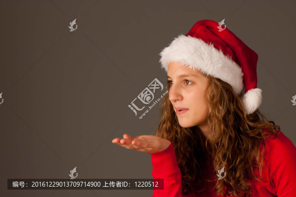 迷人的女孩在圣誕帽孤立的灰色背景