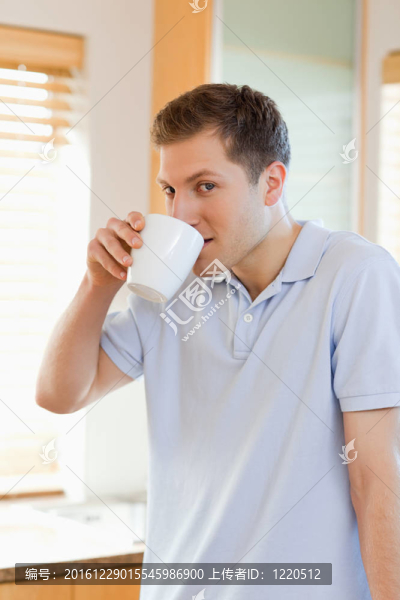 男人從杯子里喝了些咖啡