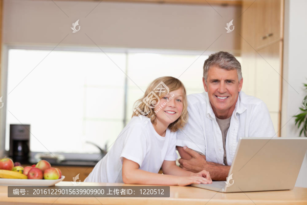 帶著筆記本的爸爸和兒子微笑