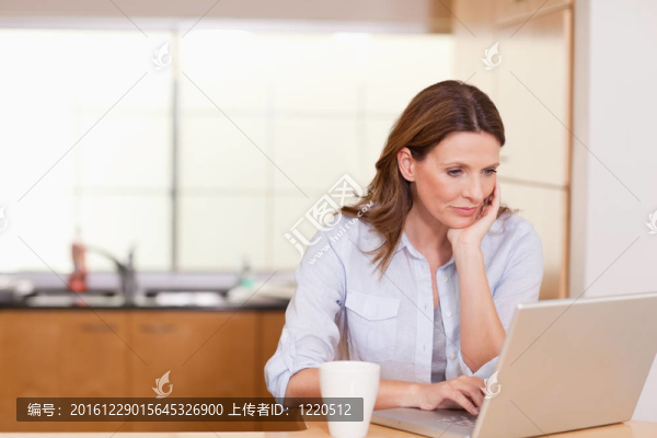 女人在廚房里拿著筆記本