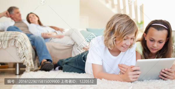 兄弟姐妹與平板電腦在地板上