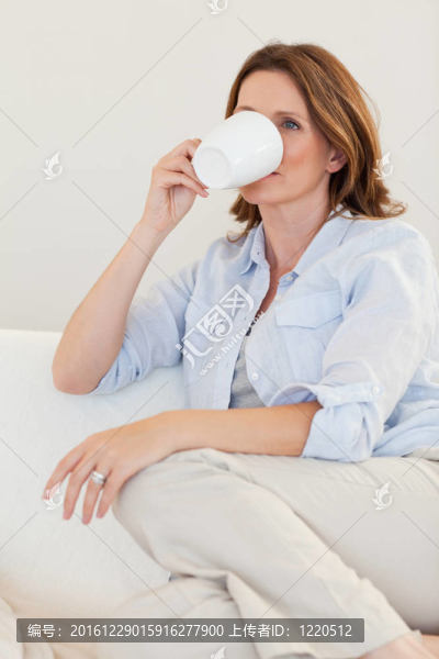 女人在沙發(fā)上喝咖啡