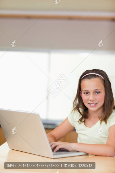 在廚房里使用筆記本電腦的女孩