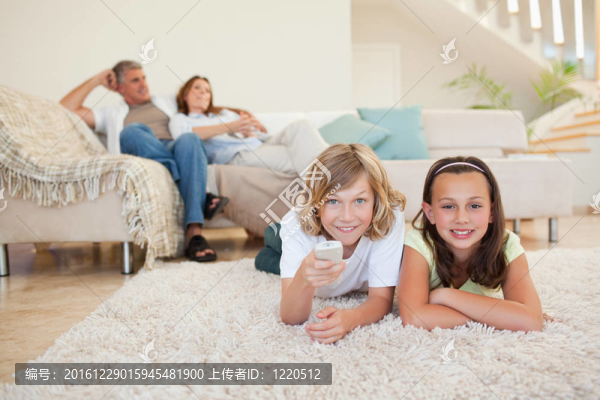 兄弟姐妹在地毯上看電視