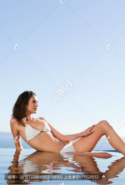 女人在泳池邊享受陽光
