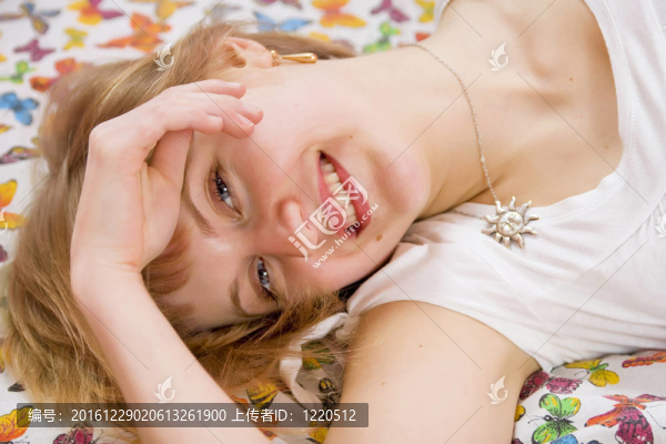 美麗的金發(fā)女孩躺在床上。毯子的蝴蝶