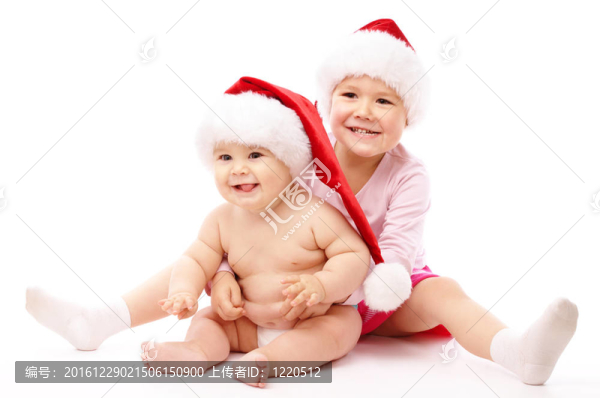 兩個孩子穿著紅色的圣誕帽和微笑