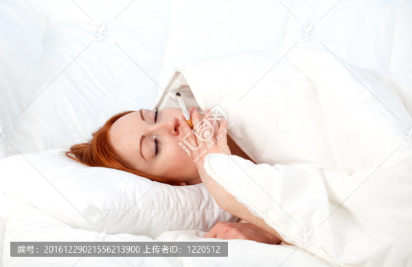 吸煙美麗的年輕女子在白色床上用品放松