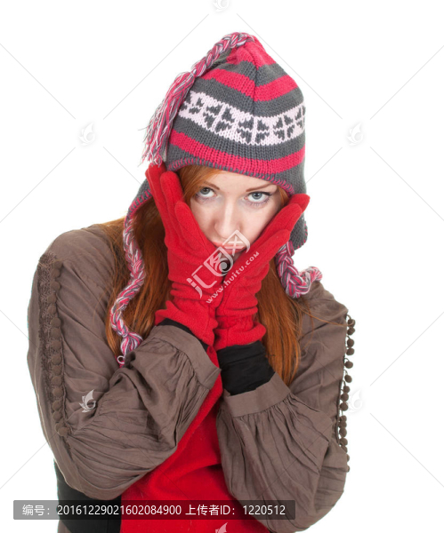 站在冬天的帽子和紅色的手套的年輕女子