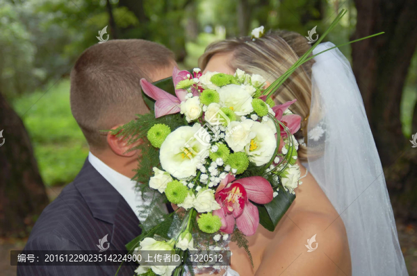 新郎和未婚妻在花束后親吻