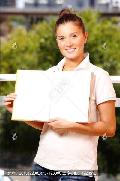 拿著自然背景書的女人