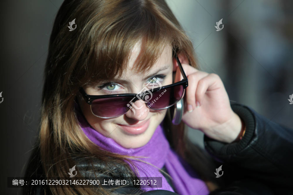 年輕漂亮的女人在太陽鏡與電話