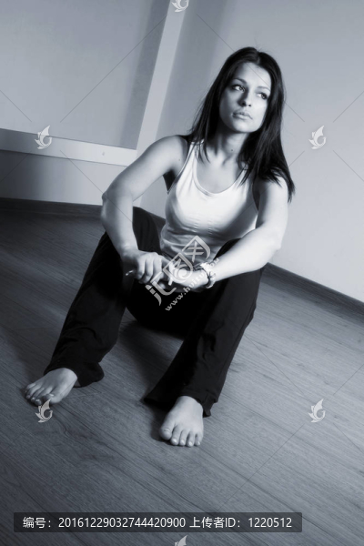 一個長著黑頭發(fā)的女孩坐在地板上