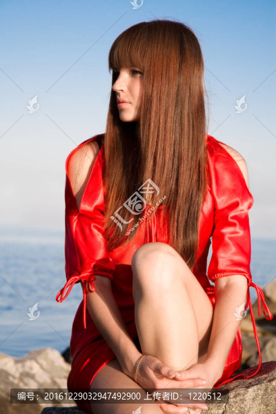 美麗的女孩坐在巖石上