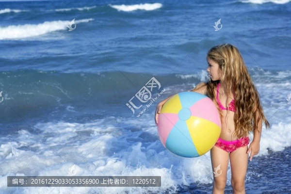 海灘小女孩彩色球在假期玩