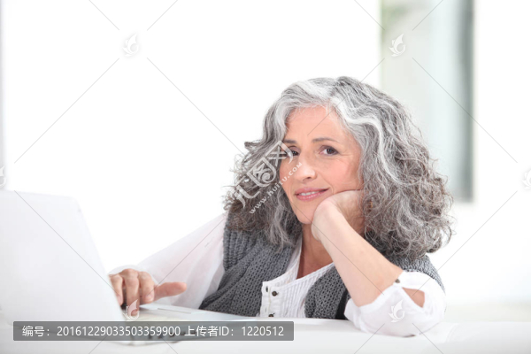 成熟的白發(fā)女士與筆記本電腦