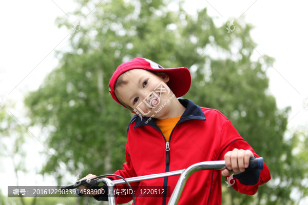 在綠色公園騎自行車的男孩
