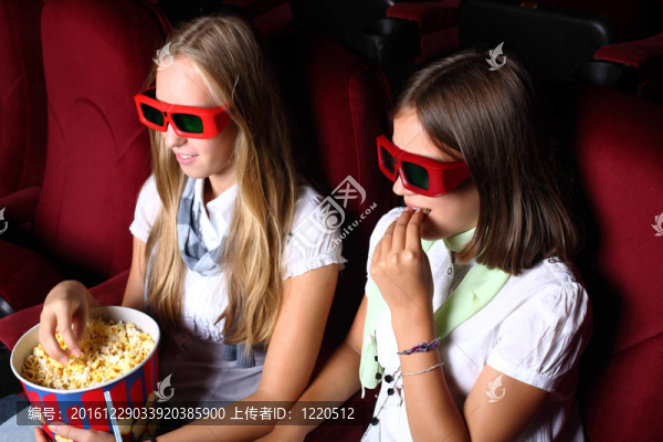兩個年輕女孩在電影院看電影